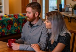 Man and woman sitting together in living room reviewing humidifier options for home comfort and air quality.