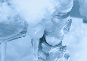Close-up view of frozen water pipes covered in thick ice buildup, illustrating winter pipe freezing conditions and potential plumbing issues.